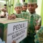Sejumlah pelajar memberikan uang sakunya untuk didonasikan kepada korban bencana alam, di Madrasah Ibtidaiyah Negeri 2 Kediri, Jawa Timur, Rabu (03/12/25). Foto: Antara/Prasetia Fauzani